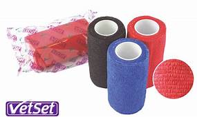 A set of red, black and blue bandages, with a red bandage in clear plastic packaging laying to one side.