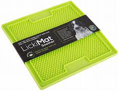A bright green square rubber mat with raised dimples. The black label surrounding it has Lickimat Soother written in white and a black & white puppy.
